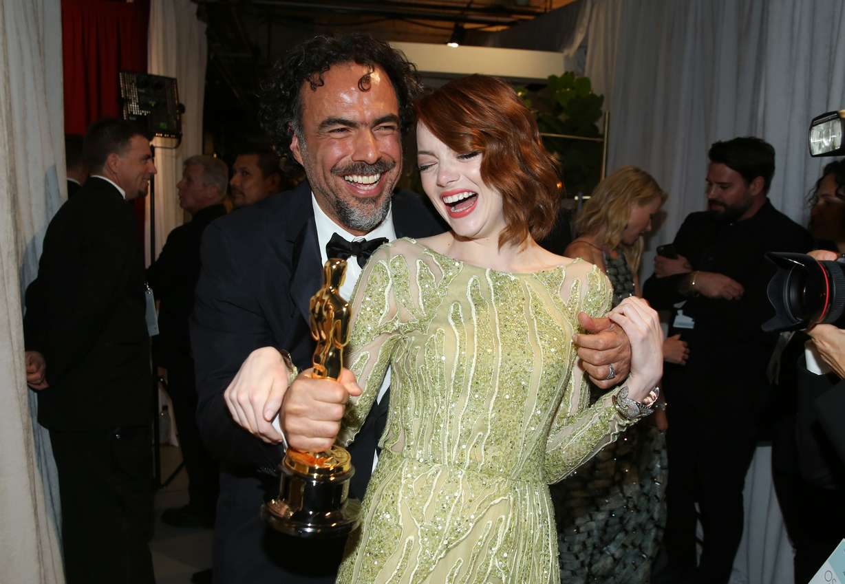 Alejandro Gonzalez Inarritu, left, and Emma Stone are seen backstage at the Oscars on Sunday, Feb. 22, 2015, at the Dolby Theatre in Los Angeles. (Photo by Matt Sayles/Invision/AP)