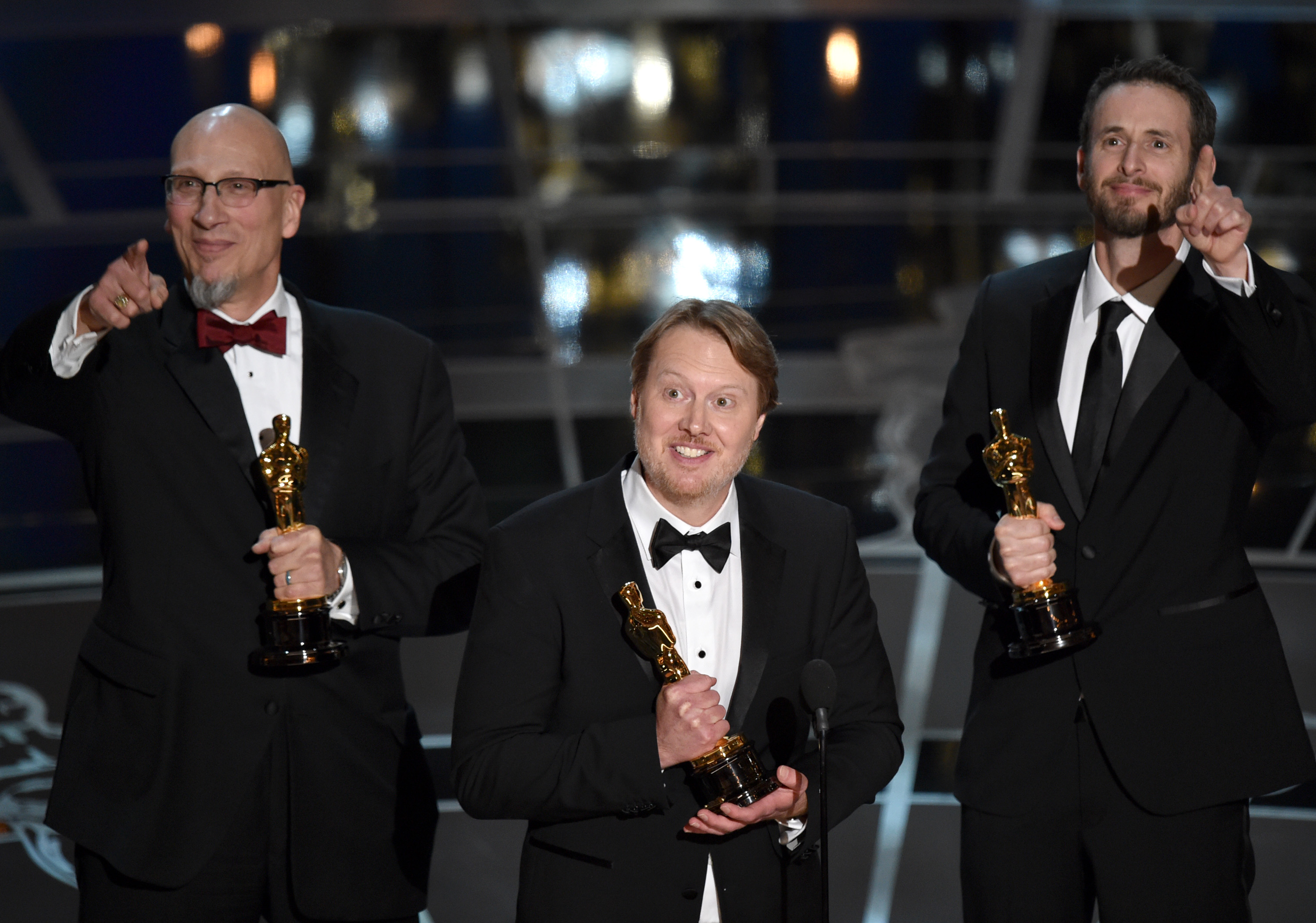 Roy Conli, from left, Don Hall, and Chris Williams accept the award for best animated feature film for "Big Hero 6" at the Oscars on Sunday, Feb. 22, 2015, at the Dolby Theatre in Los Angeles. (Photo by John Shearer/Invision/AP)