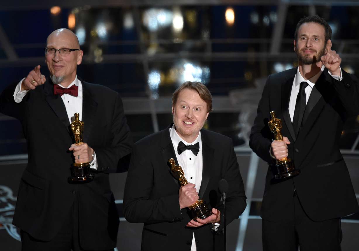Roy Conli, from left, Don Hall, and Chris Williams accept the award for best animated feature film for "Big Hero 6" at the Oscars on Sunday, Feb. 22, 2015, at the Dolby Theatre in Los Angeles. (Photo by John Shearer/Invision/AP)