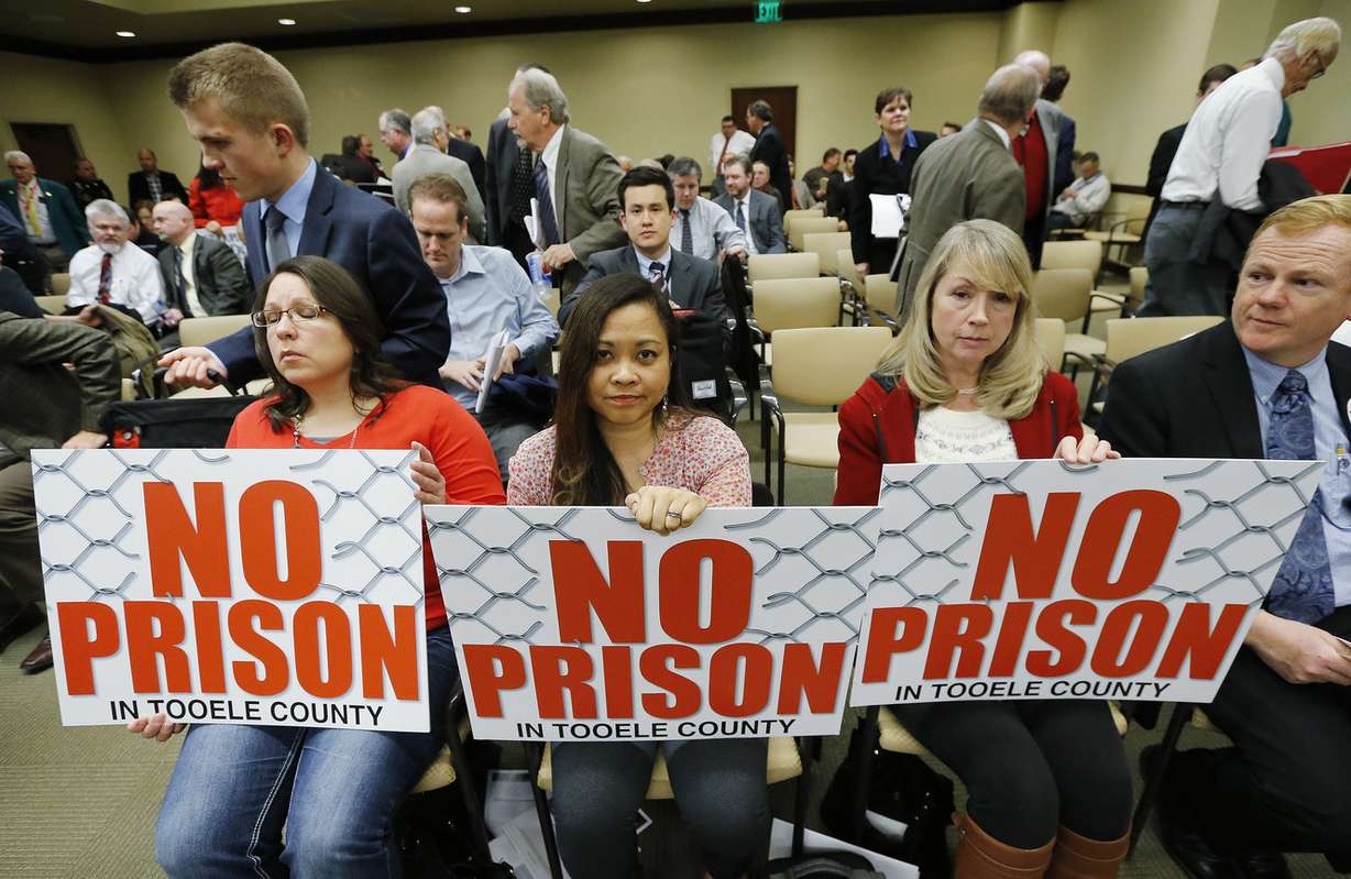 Katrina Hill, left, Jewel Allen and Susan Johnsen holds signs as the Prison Relocation Commission meets to discuss potential sites for a relocated correctional facility during the Utah Legislature in Salt Lake City Friday, Feb. 27, 2015. (Photo: Jeffrey D. Allred, Deseret News)