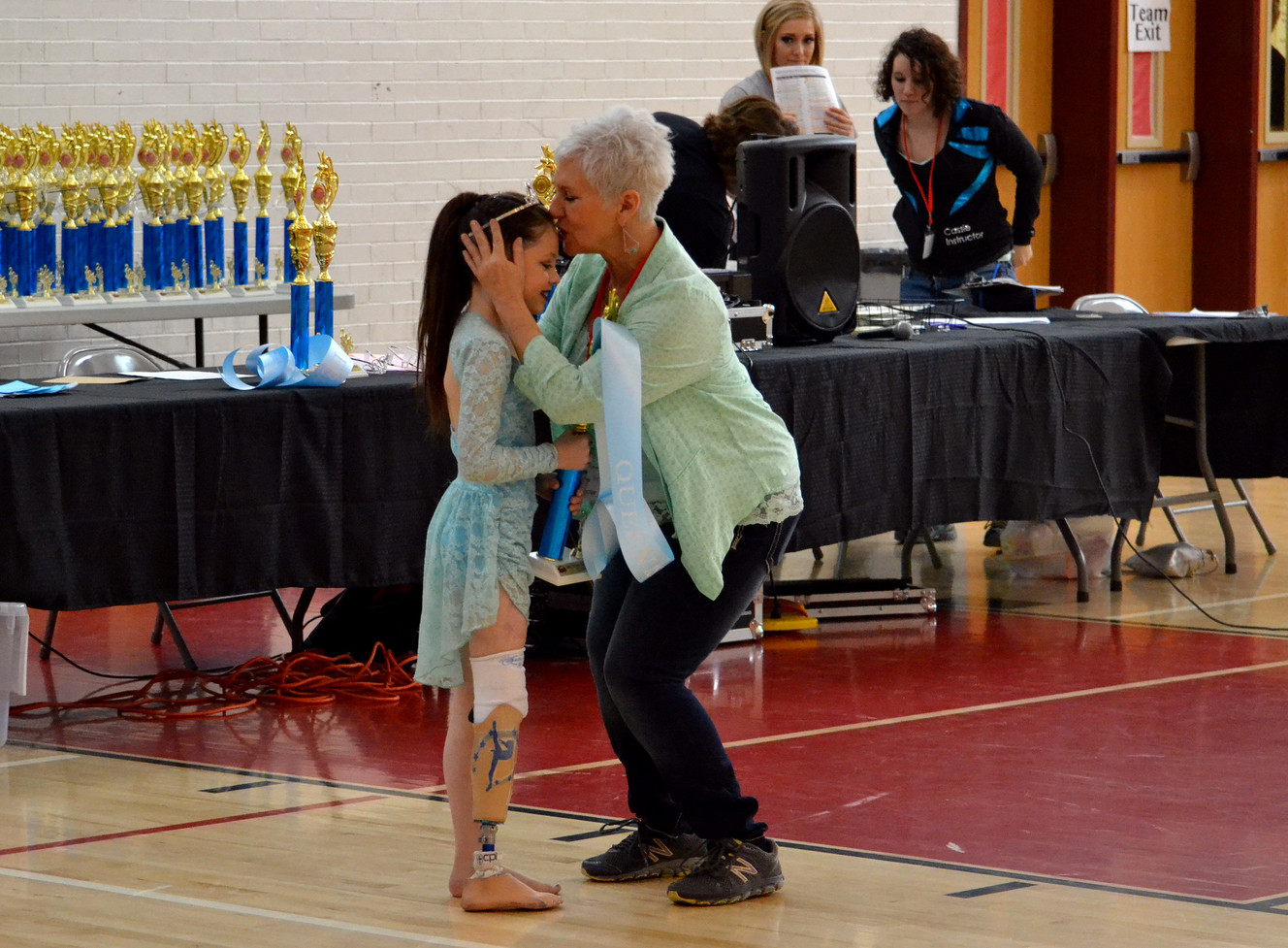 Taunia Wheeler, right, kisses Alissa Sizemore on the head during the awards presentation after Alissa's first solo performance Saturday, Feb. 28, 2015, for Powerhouse Dance Studio in Vernal. Alissa, 8, had to have her right leg amputated below the knee in May 2014 after her foot was pinned under a UPS truck. (Photo: Heather Sizemore)