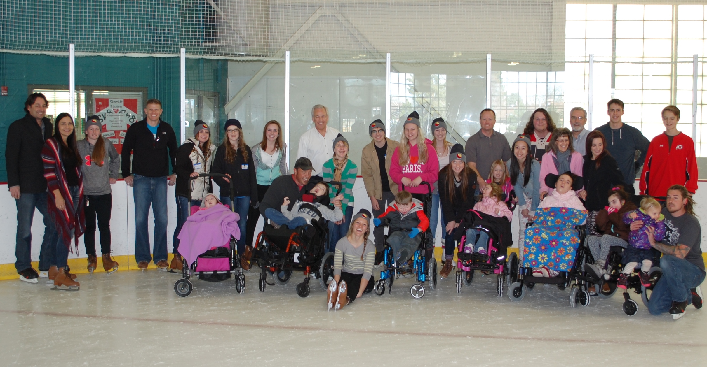 High school students ice skate with students in wheelchairs