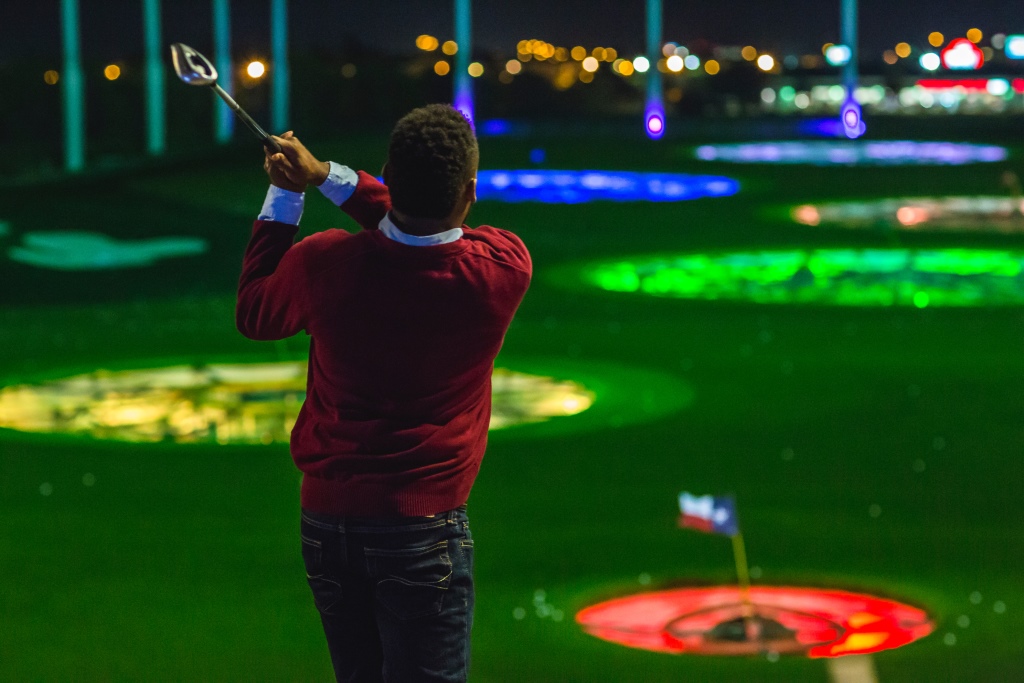 A golfer plays in a Topgolf facility (Courtesy of Topgolf)