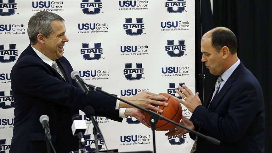 Utah State athletic director Scott Barnes, left, hands Tim Duryea a basketball as Duryea is named the new USU head basketball coach in Logan, Monday, March 30, 2015. Barnes was officially named the athletic director at Pittsburgh on Friday morning. (Ravell Call/Deseret News)