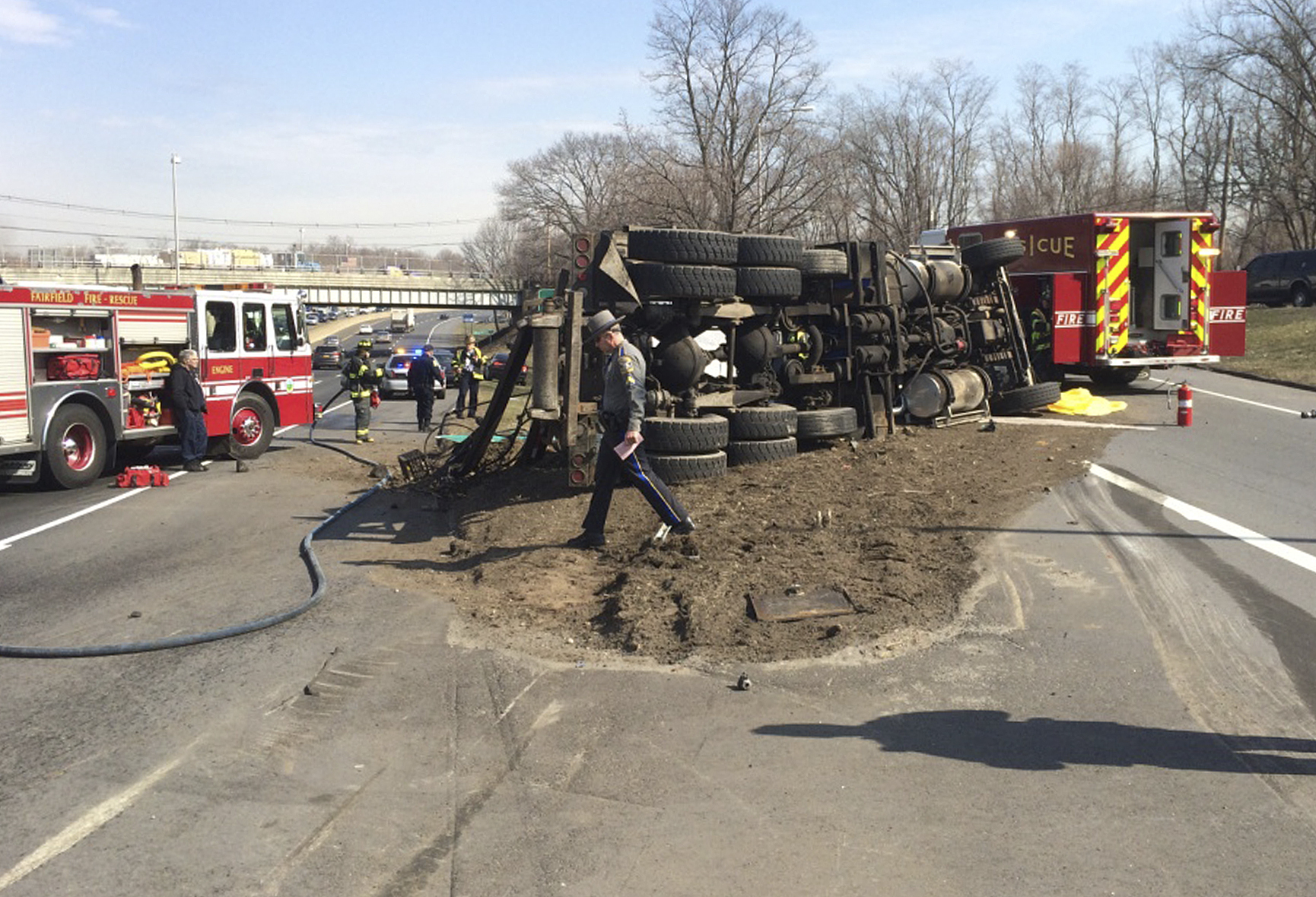 Garbage truck hits highway overpass, flips over; driver dies