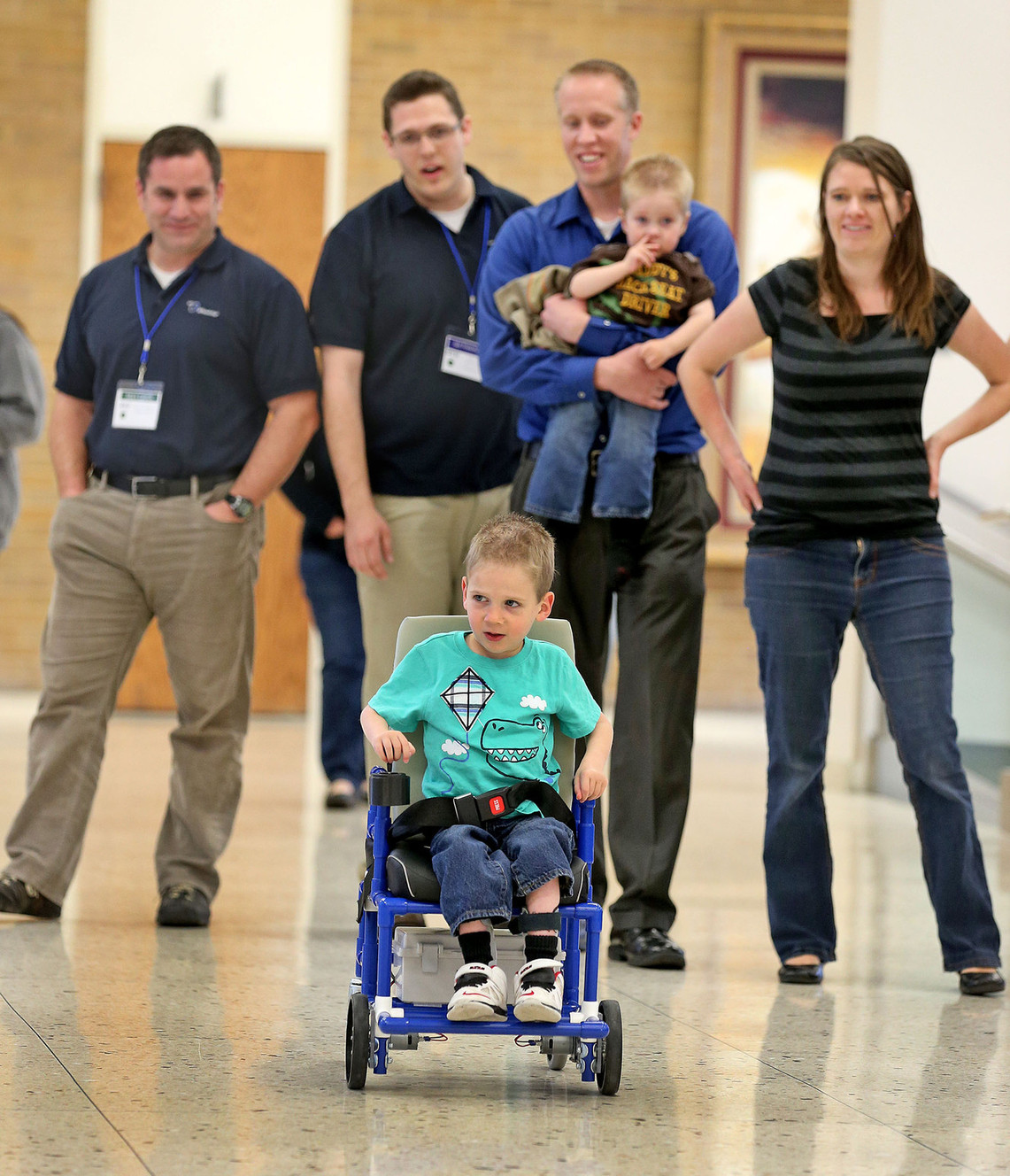 Tanner Jensen, 3, drives his new wheelchair that BYU's Engineering Capstone program has developed as his parents, Esther and Justin Jensen, and brother, Skyler, watch along with Capstone team members, Mark Colton, left, and Ian Freeman, Thursday, April 2, 2015, in Provo. The chair is the world's lightest, least expensive motorized wheelchair, made from PVC pipe.
(Photo: Tom Smart, Deseret News)
