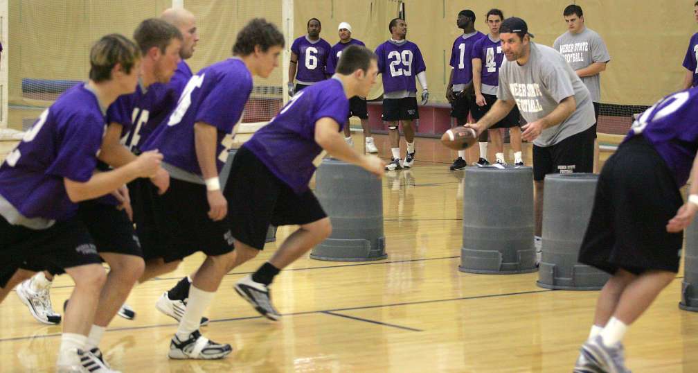 Weber State defensive coordinator Kevin Clune (black hat) works with football players as they go through drills as part of practice on Saturday morning, April 9, 2005. (August Miller/Deseret Morning News/File)