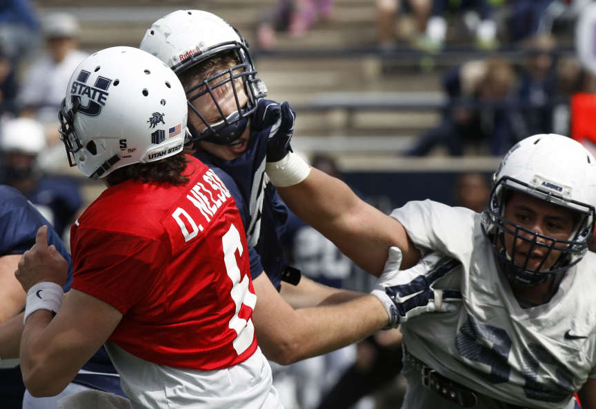Utah State's defense puts pressure on quarterback DJ Nelson during a football scrimmage in the former Romney Stadium, now Maverik Stadium, at Utah State University on Saturday, April 11, 2015. (Chelsey Allder/Deseret News)