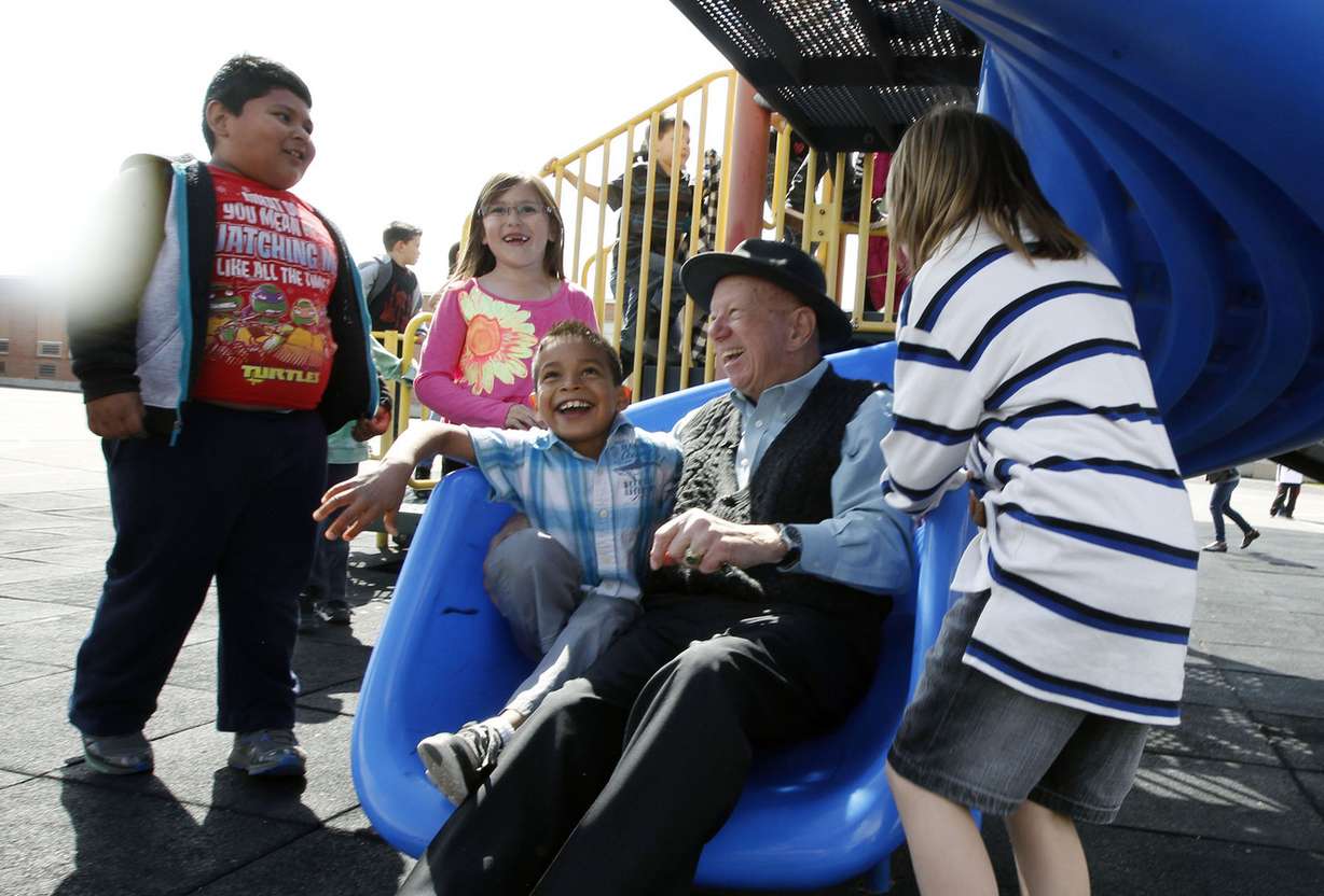 Veteran Eugene Ward, 83, rides a slide with Sergio Landeros Benitez. Ward helps tutor children in Marta Welch's first-grade classroom at Redwood Elementary School in West Valley City on Thursday, April 9, 2015. (Photo: Chelsey Allder, Deseret News)