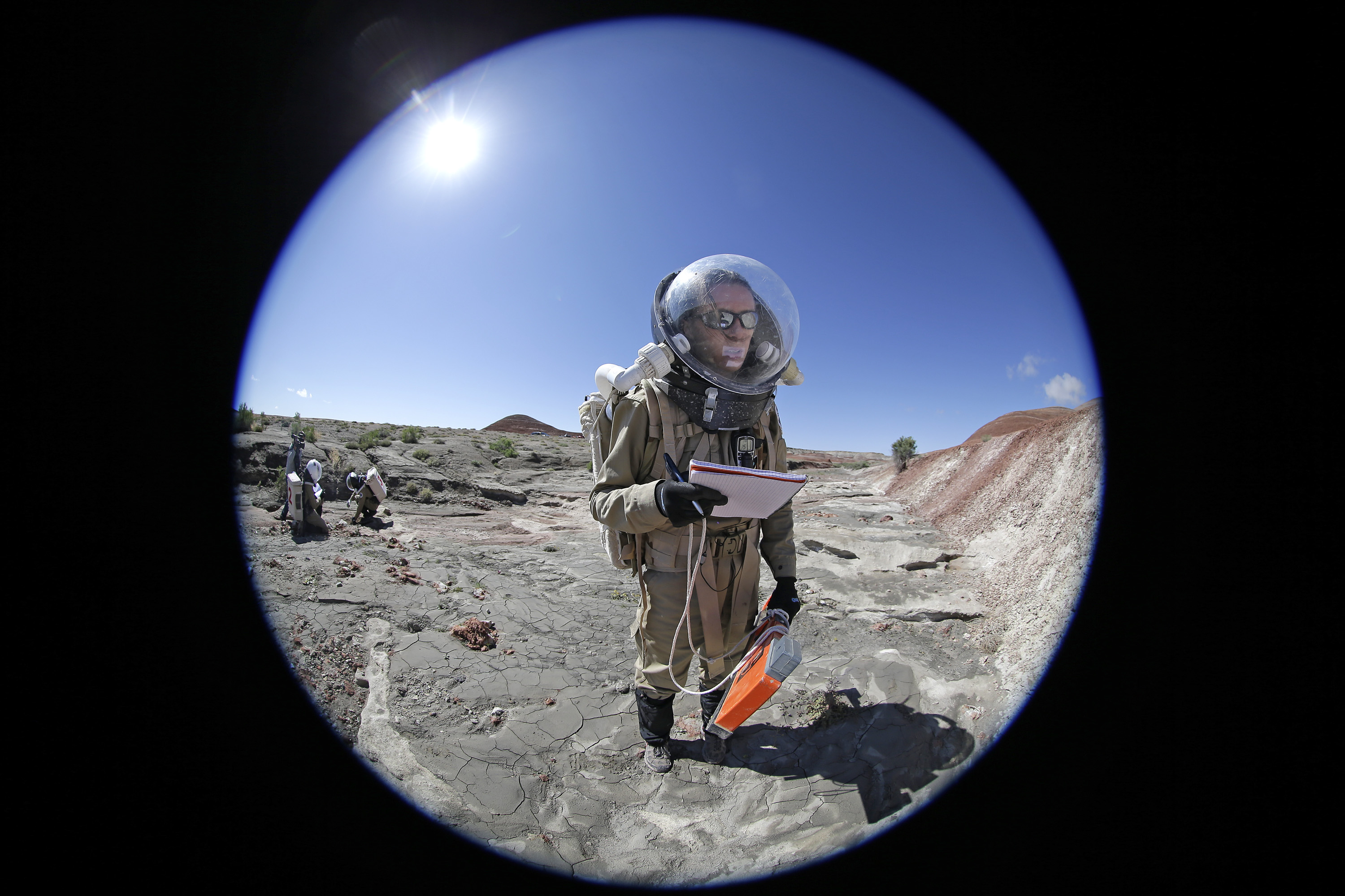 In this photo taken on Saturday, April 18, 2015, Auriane Canesse, crew geologist and health and safety officer, of Crew 153, takes magnetic readings of the ground using a large rectangular apparatus near the Mars Desert Research Station, in Hanksville, Utah. This isn't Mars, but it's resemblance to the red planet has made it a hot spot for teams of geologists, biologists and engineers from around the world who have been coming for more than a decade to simulate missions to the mysterious planet in hopes of providing critical research to for future trips to Mars. (AP Photo/Rick Bowmer)