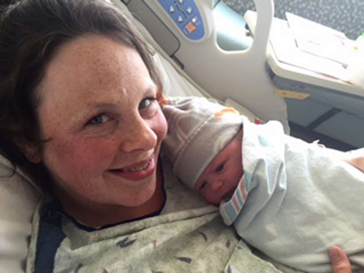 In this photo provided by Jay Schwandt, his wife, Kateri Schwandt holds her baby boy Wednesday, May 13, 2015, in Grand Rapids, Mich. The couple who already had 12 sons have kept the all-male streak alive with the birth of boy No. 13 (Jay Schwandt via AP)