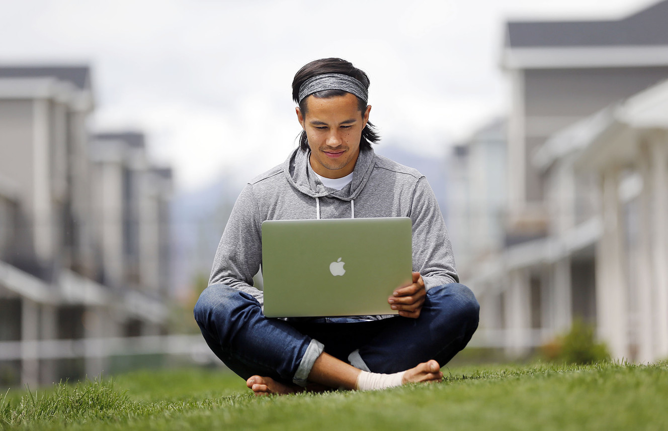 Garrett Gee works on his laptop outside his home in Vineyard, Utah County, Wednesday, May 20, 2015. Photo: Ravell Call, Deseret News