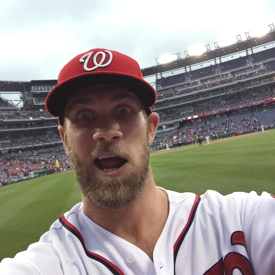 Washington Nationals outfielder Bryce Harper takes a photo of himself with a cell phone tossed to him by fan Jamie Roach, Tuesday, June 2, 2015, at Nationals Park in Washington. (Credit: The Associated Press)