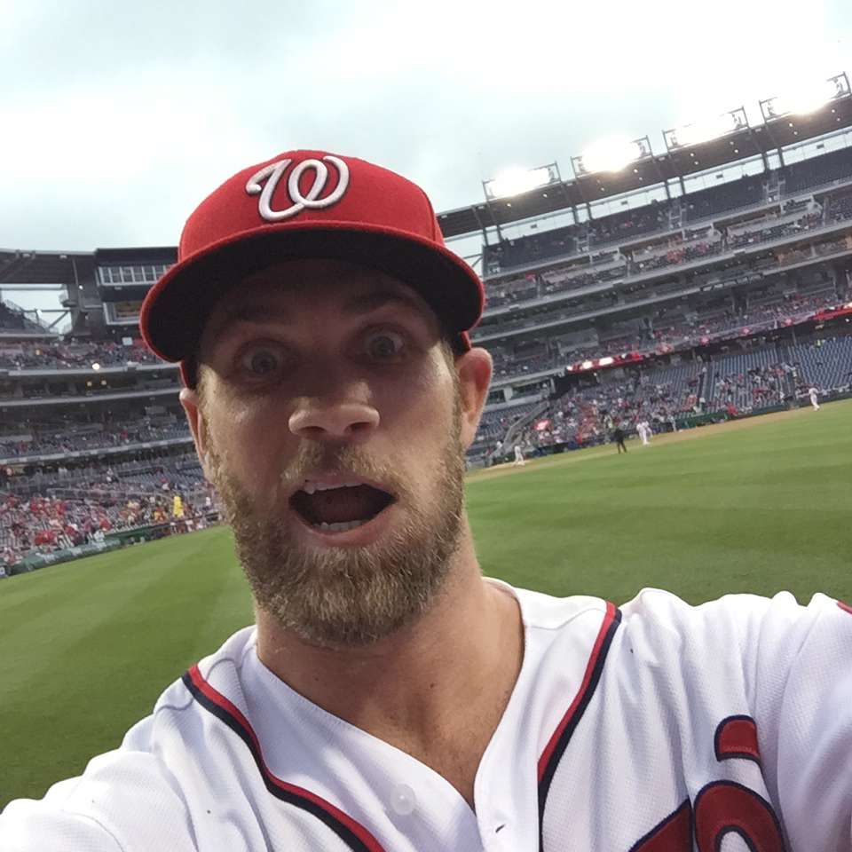 Washington Nationals outfielder Bryce Harper takes a photo of himself with a cell phone tossed to him by fan Jamie Roach, Tuesday, June 2, 2015, at Nationals Park in Washington. (Credit: The Associated Press)