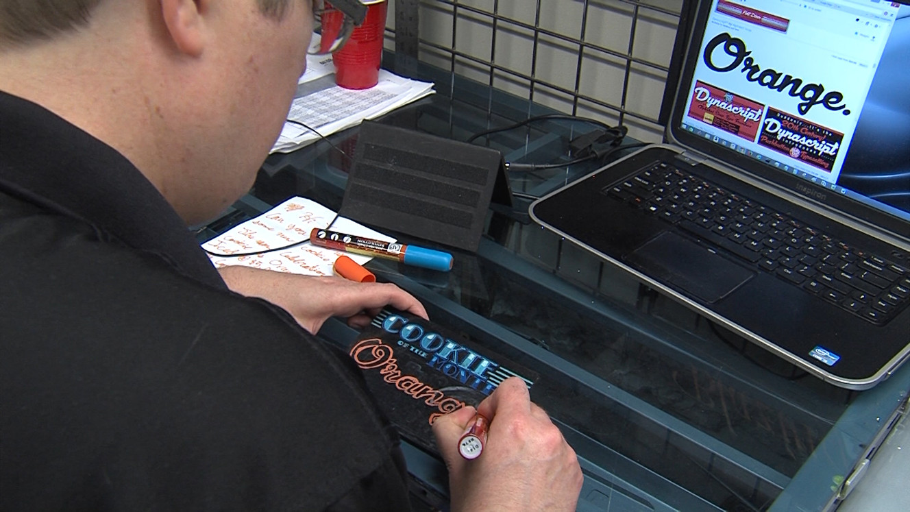 Sign artist Taylor Hellewell works in the Emigration Market store. (Photo: KSL)