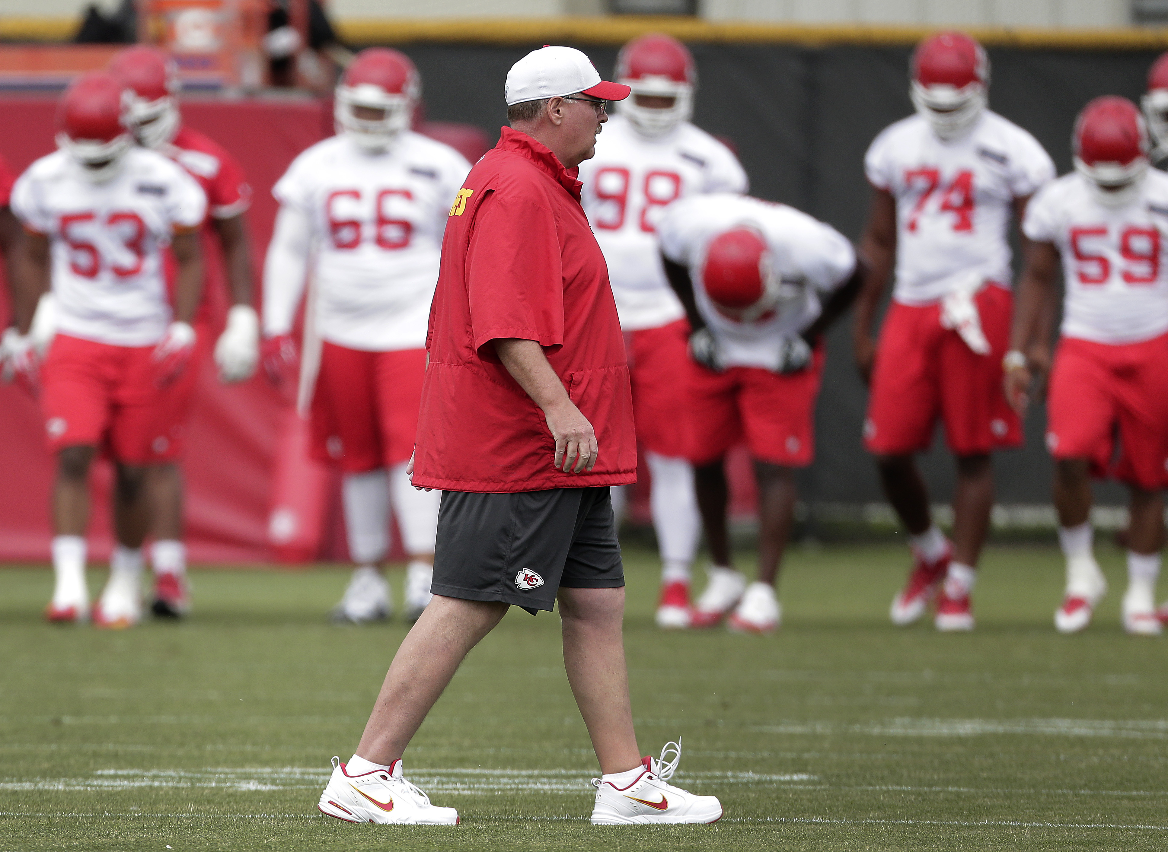 Kansas City Chiefs coach Andy Reid watches an organized team activity on June 11, 2015, in Kansas City, Mo. He's had to get used to wearing a lot of red since coming over to the Chiefs: "I'm trying to get used to all that. I'm working through it." (AP Photo/Charlie Riedel)