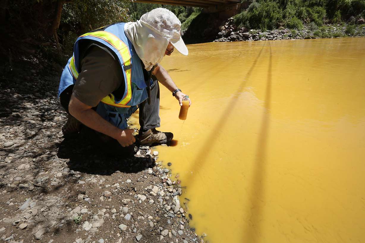 Dan Bender, with the La Plata County Sheriff's Office, takes a water sample from the Animas River near Durango, Colo., Thursday, Aug. 6, 2015. Photo: AP Photo