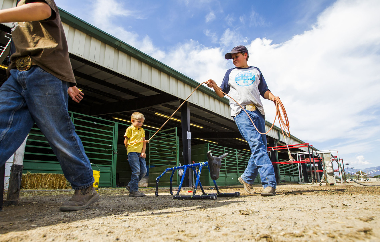 Tatum Orton, 3, gets jokingly tied up by Cameron Simmons, 12, at the Salt Lake County Fair in South Jordan on Saturday, Aug. 15, 2015. (Photo: Stacie Scott, Deseret News)