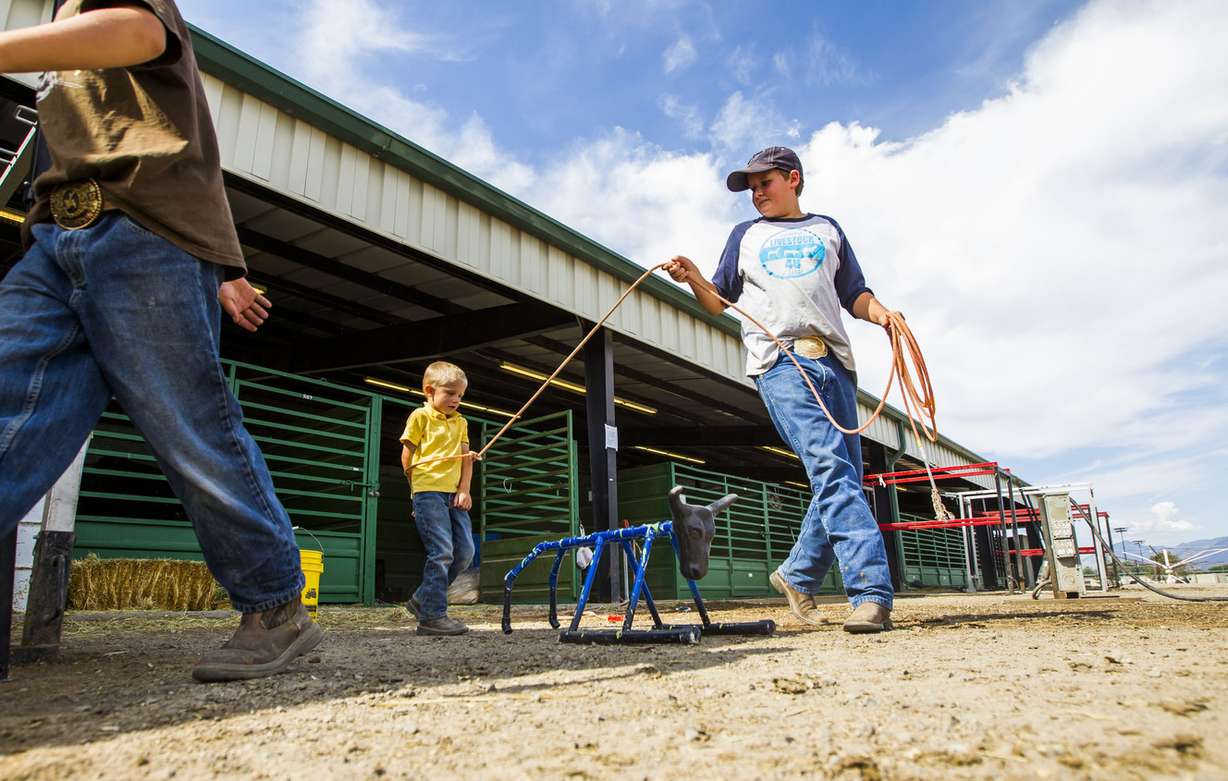Tatum Orton, 3, gets jokingly tied up by Cameron Simmons, 12, at the Salt Lake County Fair in South Jordan on Saturday, Aug. 15, 2015. (Photo: Stacie Scott, Deseret News)
