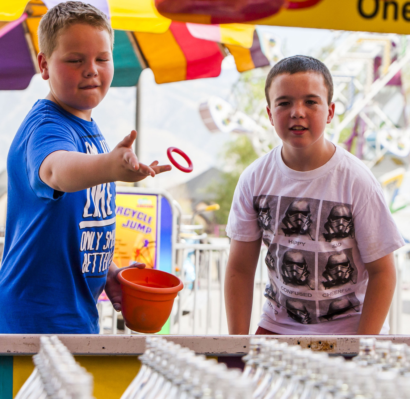 Hunter Craig, 13, and Colton Case, 11, toss rings onto bottles at the 79th-annual Salt Lake County Fair in South Jordan on Saturday, Aug. 15, 2015. (Photo: Stacie Scott, Deseret News)
