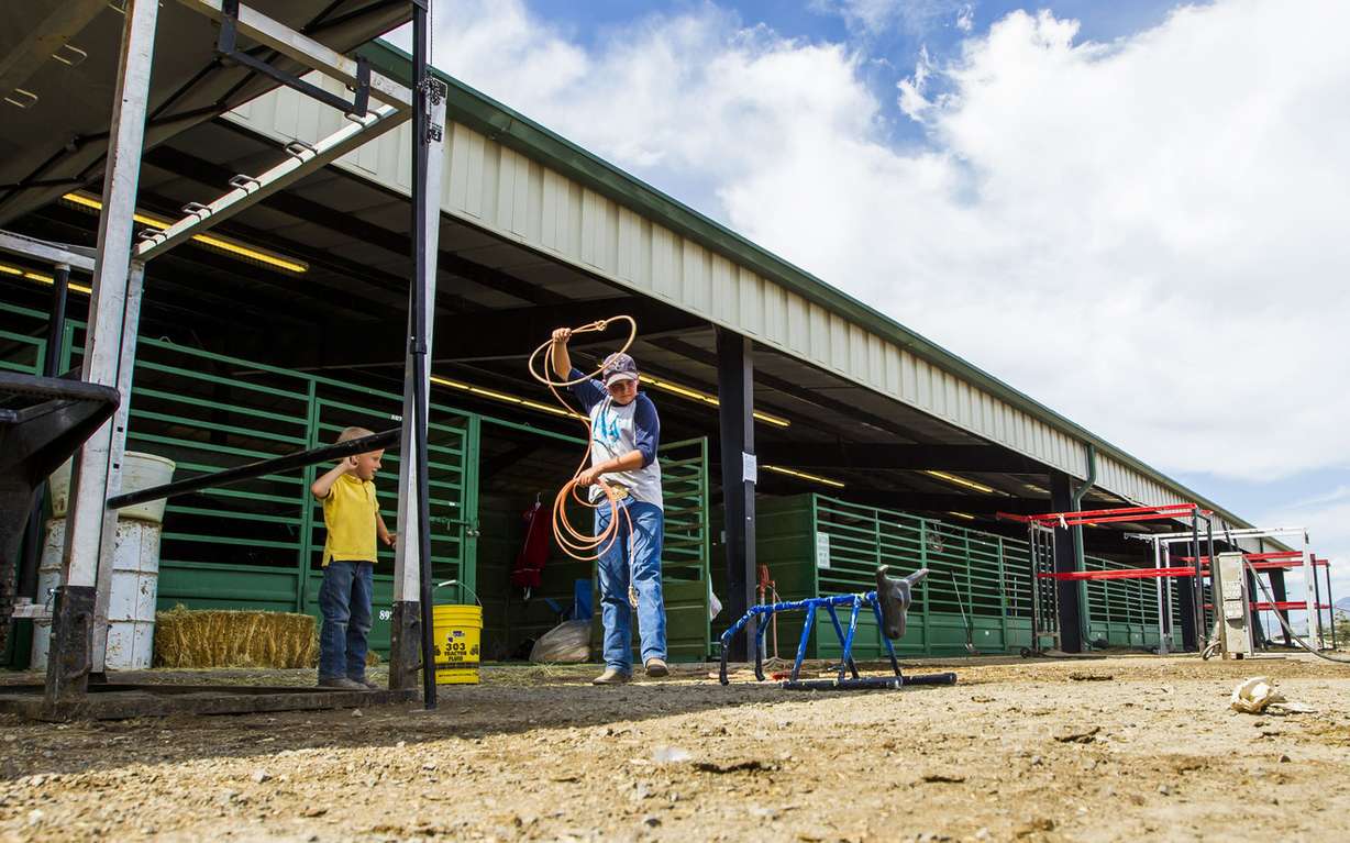 Tatum Orton, 3, watches as Cameron Simmons, 12, practice calf roping at the Salt Lake County Fair in South Jordan on Saturday, Aug. 15, 2015. (Photo: Stacie Scott, Deseret News)