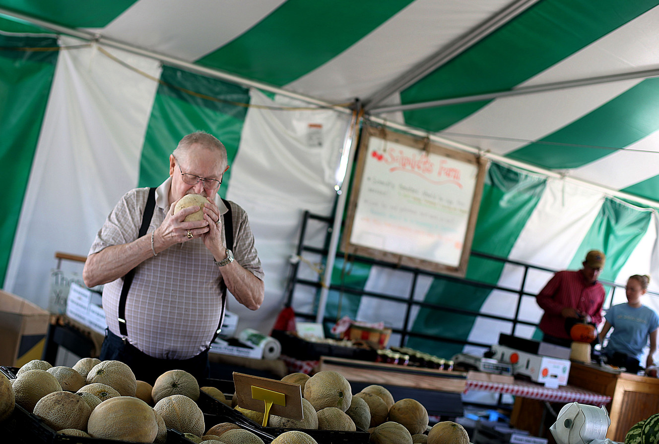 Lowell Wolcott smells a cantaloupe at Schmidt's produce stand in West Jordan on Wednesday, Aug. 12, 2015. (Photo: Laura Seitz, Deseret News)