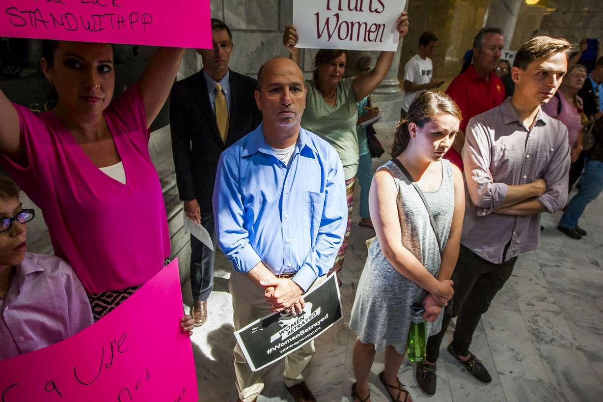 Tony Escobar and Tina Escobar-Taft, who stand in support of Planned Parenthood, Mike Cuollo, who opposes Planned Parenthood, and Rachel Adams and Max Eyres, also supporting Planned Parenthood, listen during a rally to encourage the defunding of Planned Parenthood at the state Capitol in Salt Lake City on Wednesday, Aug. 19, 2015.
(Photo: Stacie Scott/Deseret News)