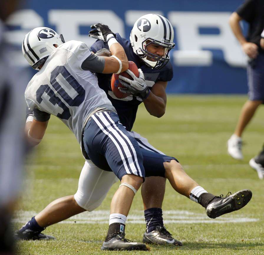 Paul Lasike runs the ball while being defended by Micah Hannemann during BYU football practice in Provo, Aug. 16, 2012. (Photo: Ravell Call, Deseret News)