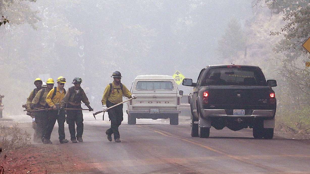 The Latest: Crews fight fire near Montana highway