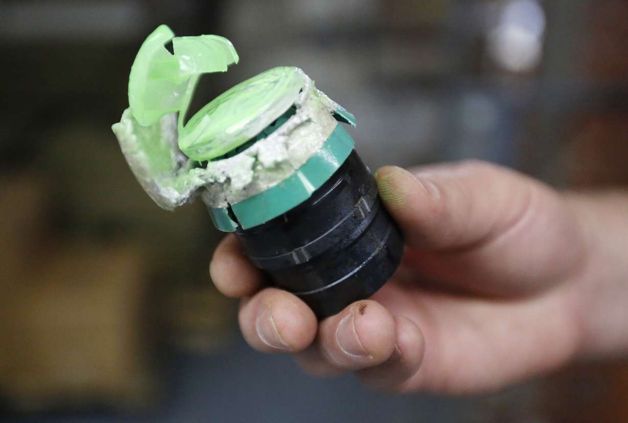 In this Thursday, July 30, 2015 photo, a 40mm Blunt Impact Projectile that releases green marking powder on impact is displayed after being fired at a test dummy at Micron Products, Inc., in Fitchburg, Mass. The projectiles utilize new technology developed by the company to provide law enforcement with less-lethal ammunition engineered to cushion and displace the force of impact, designed to cause pain and discomfort but not serious injury. The technology is part of a push to find ways for law enforcement to be able to use force with non-deadly means. (AP Photo/Steven Senne)