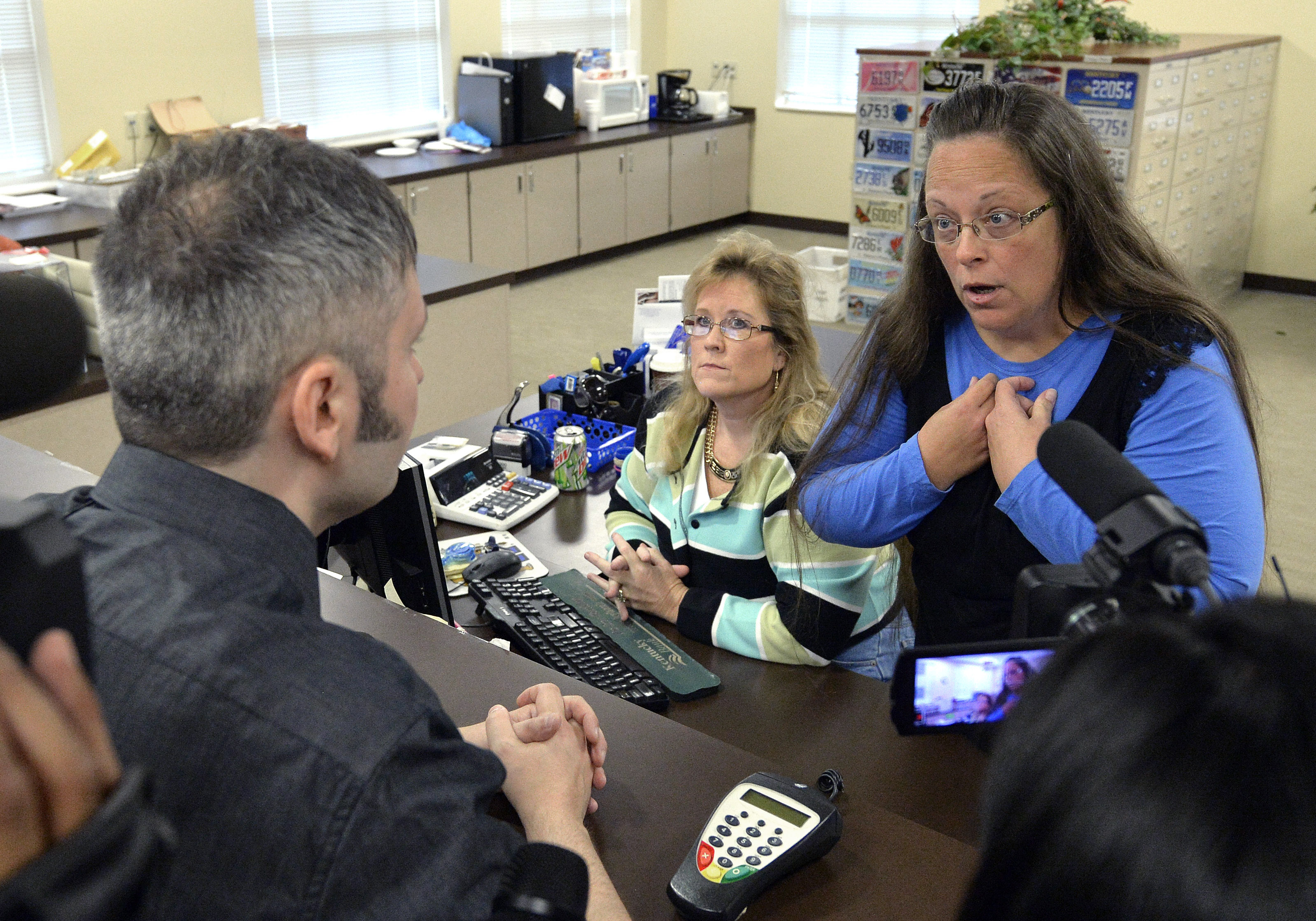 Rowan County Clerk Kim Davis, right, talks with David Moore following her office's refusal to issue marriage licenses at the Rowan County Courthouse in Morehead, Ky., Tuesday, Sept. 1, 2015. Although her appeal to the U.S. Supreme Court was denied, Davis still refuses to issue marriage licenses. (AP Photo/Timothy D. Easley)