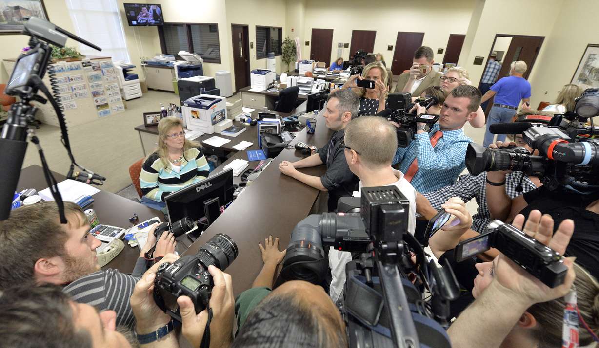 Surrounded by the media, David Moore, center, and his partner David Ermold attempt to apply for a marriage license at the Rowan County Courthouse in Morehead, Ky., Tuesday, Sept. 1, 2015. Although her appeal to the US Supreme Court was denied, Rowan County Clerk Kim Davis still refuses to issue marriage licenses. (AP Photo/Timothy D. Easley)