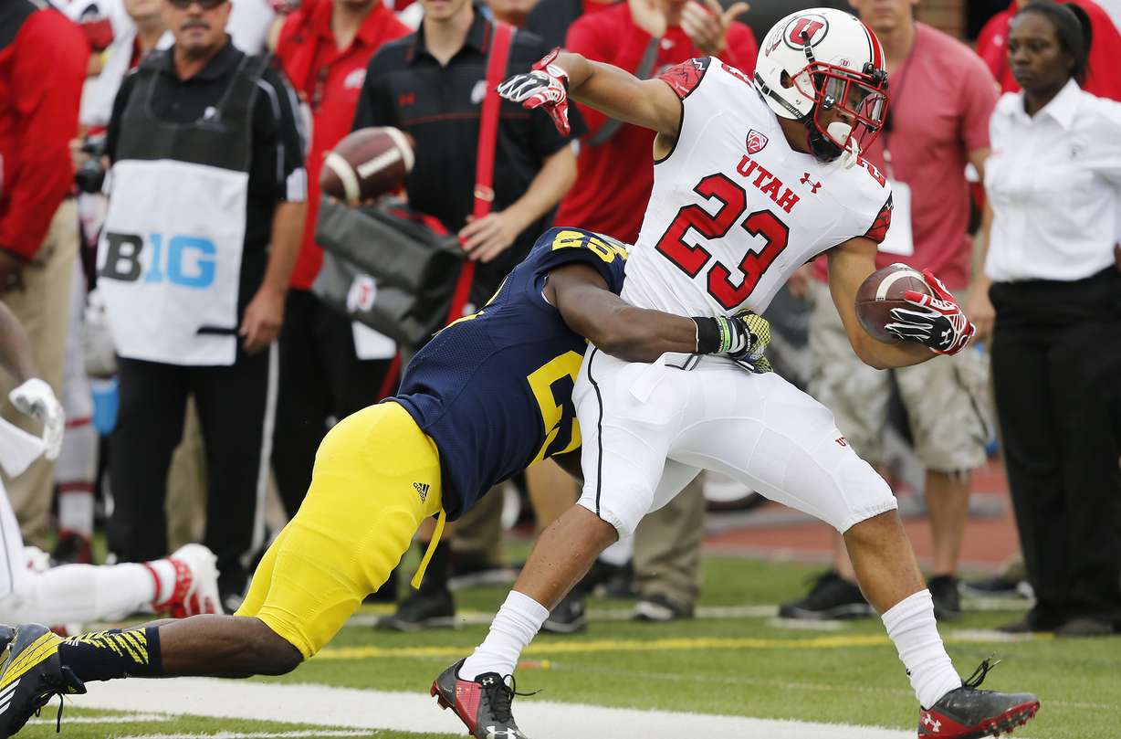Utah Utes running back Devontae Booker (23) runs against Michigan Wolverines defensive back Dymonte Thomas (25) in Ann Arbor, Michigan Saturday, Sept. 20, 2014. Utah lead Michigan 26-10 in the fourth quarter before a lightning delay. (Photo: Jeffrey D. Allred/Deseret News)