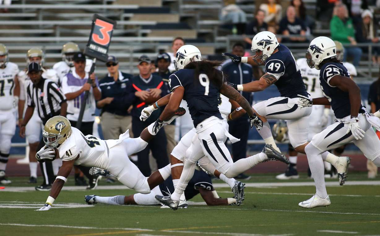 Nevada defenders Matthew Lyons (9), Jordan Dobrich (49) and Bryan Lane Jr. pursue UC Davis running back Joshua Kelley (41) during the first half of an NCAA college football game in Reno, Nev., on Thursday, Sept. 3, 2015. (AP Photo/Cathleen Allison)