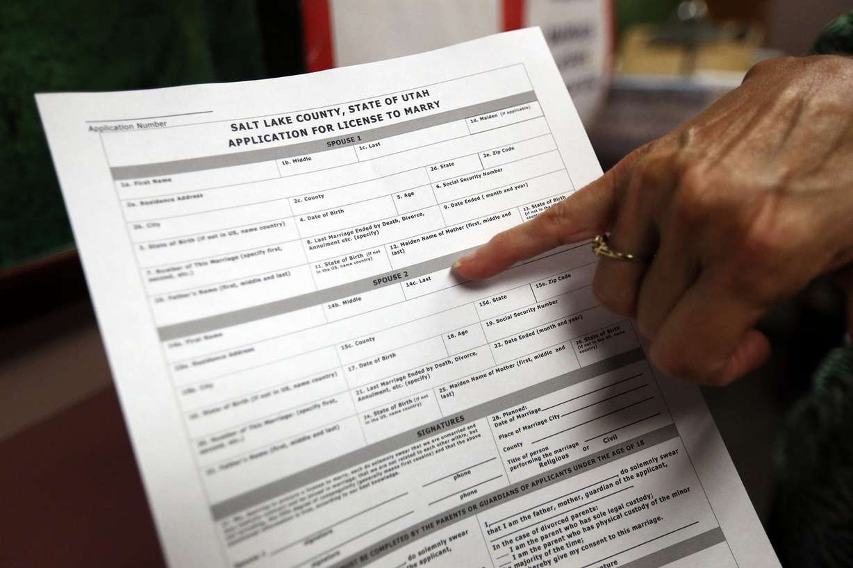 Darylne McPheeters points out how new marriage applications forms say spouse 1 and spouse 2 instead of bride and groom at the County Clerk's Office in Salt Lake City on Thursday, Sept. 3, 2015. (Photo: Kristin Murphy, Deseret News)
