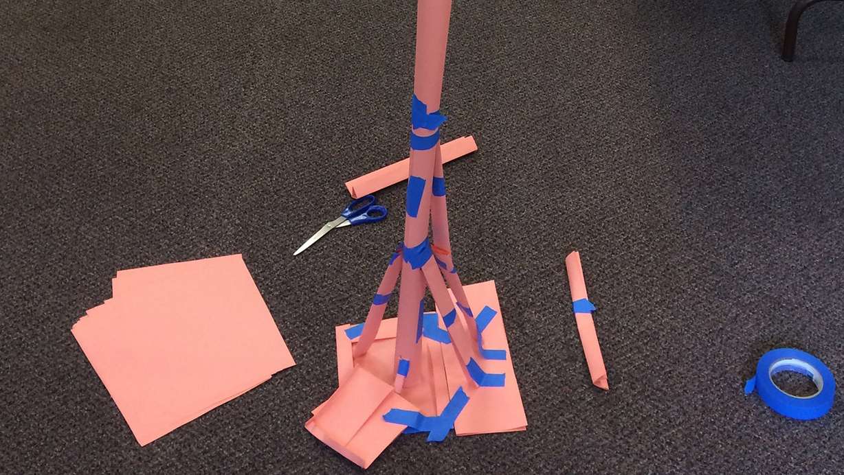 Teens construct a tower out of paper and tape. Photo: Carrie Rogers-Whitehead