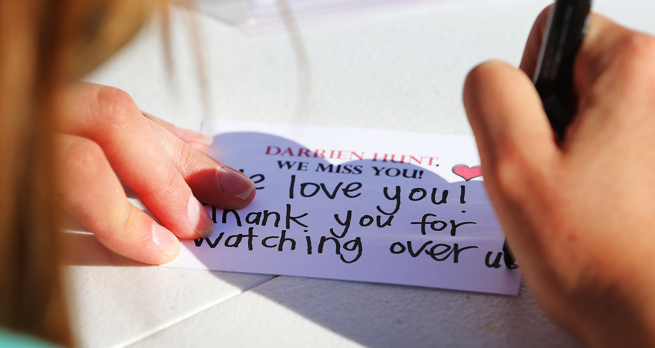 Crystal Brown writes a note as family and friends of Darrien Hunt gather Thursday, Sept. 10, 2015, in Saratoga Springs on the one-year anniversary of Hunt's death. He was shot and killed by police officers. (Photo: Scott G Winterton, Deseret News)