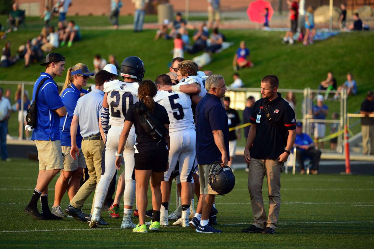 Cameron Forte is carried off the field by his Corner Canyon teammates after fracturing a femur during the Chargers' season opener against Pleasant Grove. (Photo: Richard Green)