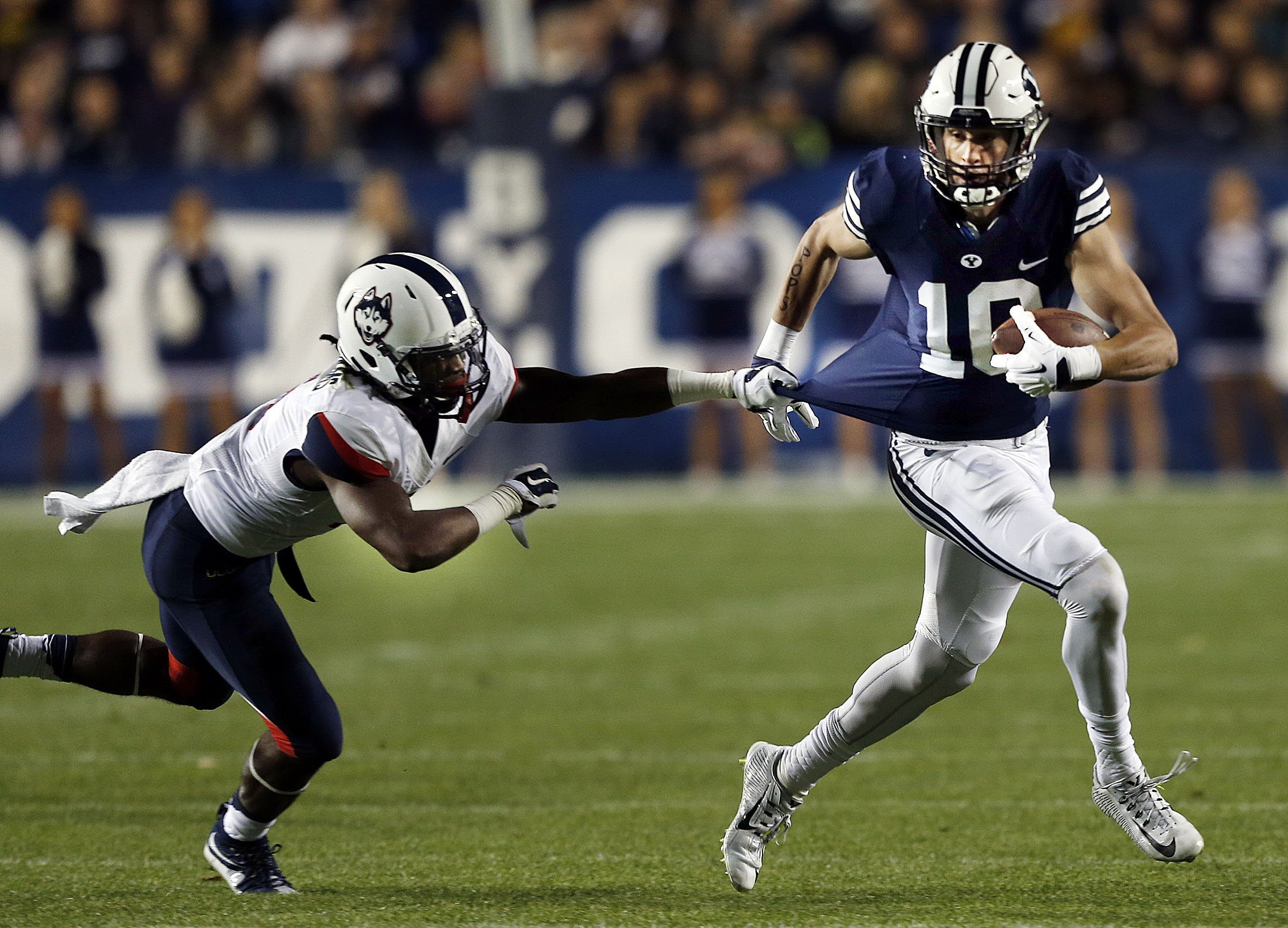 Jhavon Williams (6) of the Connecticut Huskies pulls down Mitch Mathews (10) of Brigham Young during NCAA football in Provo, Friday, Oct. 2, 2015. (Photo: Ravell Call, Deseret News)