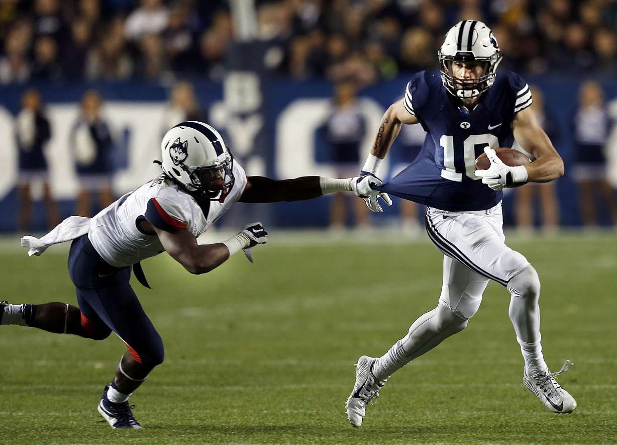 Jhavon Williams (6) of the Connecticut Huskies pulls down Mitch Mathews (10) of Brigham Young during NCAA football in Provo, Friday, Oct. 2, 2015. (Photo: Ravell Call, Deseret News)