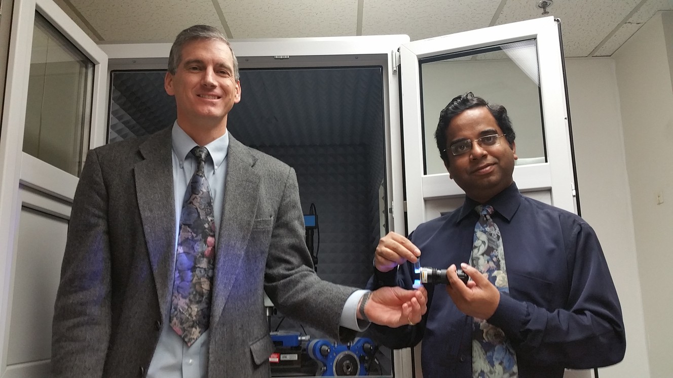 Michael Free (left) holds a light emitting diode and Prashant Sarswat (right) holds carbon dots in suspension. (Photo: Prashant Sarswat/University of Utah)