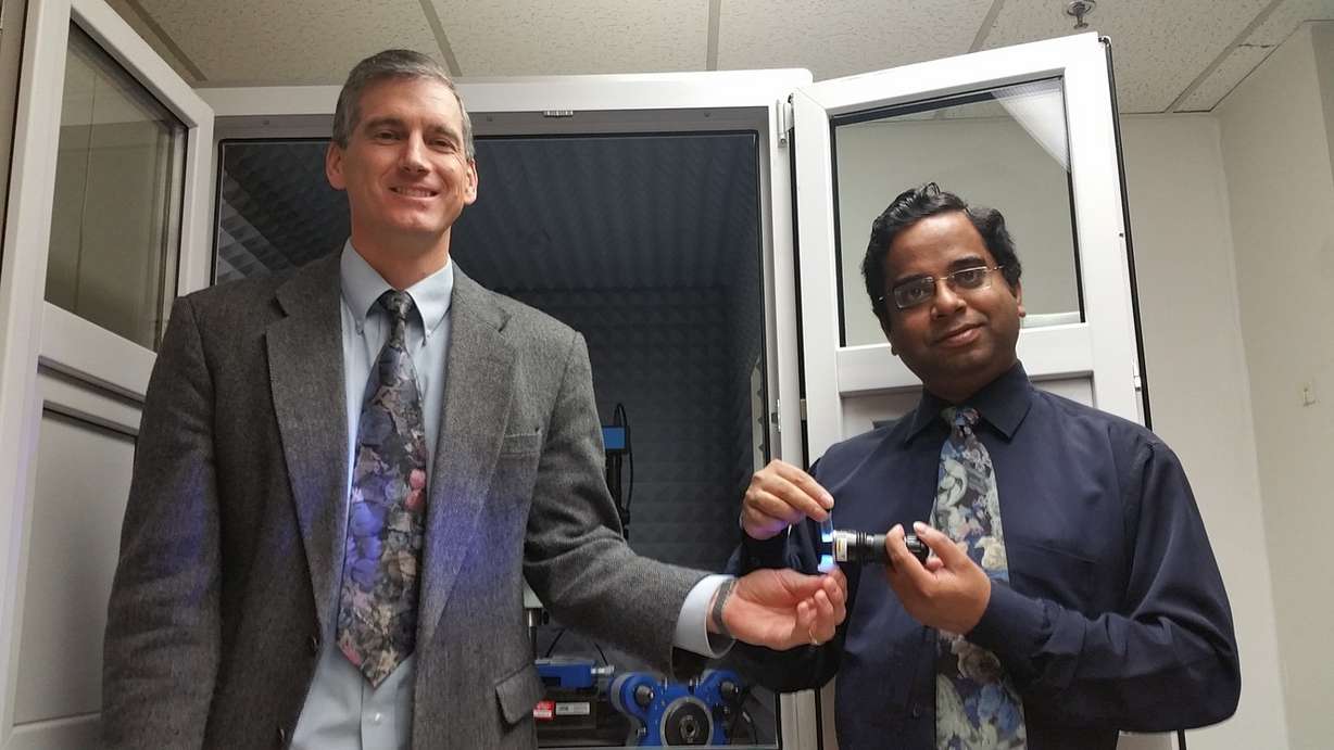 Michael Free (left) holds a light emitting diode and Prashant Sarswat (right) holds carbon dots in suspension. (Photo: Prashant Sarswat/University of Utah)