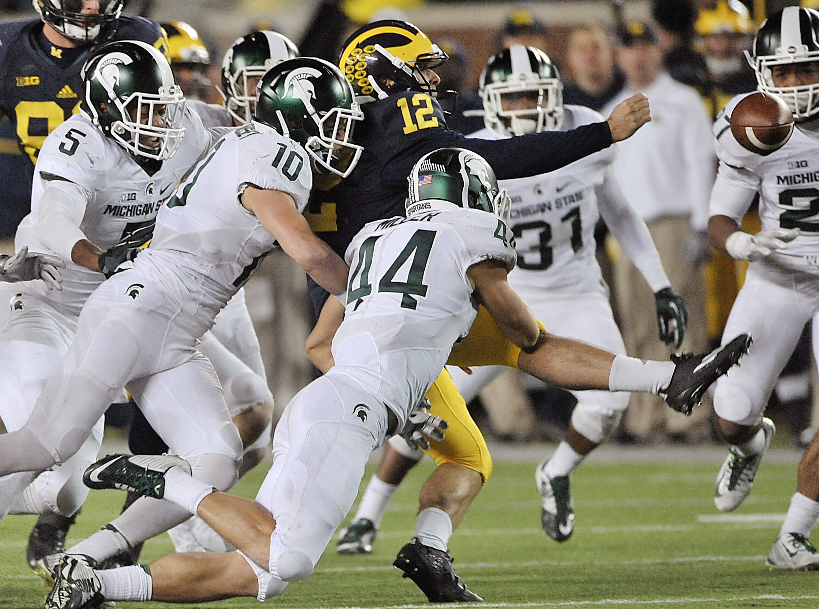 Michigan punter Blake O'Neill (12) fumbles a flubbed punt against Michigan State in the closing seconds of the second half of an NCAA college football game Saturday, Oct 17, 2015 in Ann Arbor, Mich. (AP Photo)