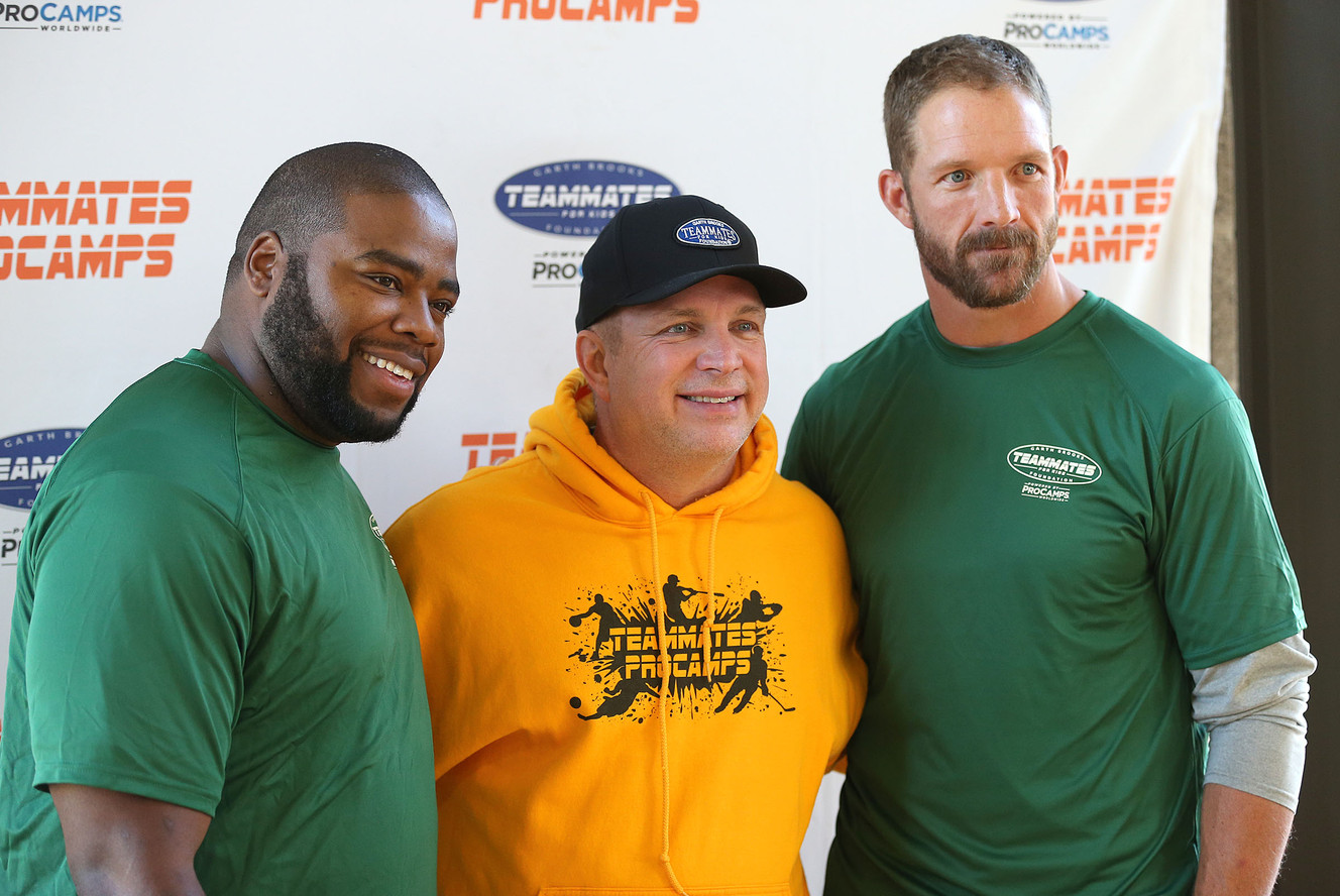 Garth Brooks, with former NFL players Daniel Coats, left, and Ryan Denney as the Garth Brooks Teammates for Kids Foundation and ProCamps team up to put on a clinic for underprivileged children, Saturday, Oct. 31, 2015, in Salt Lake City. (Photo: Tom Smart, Deseret News)