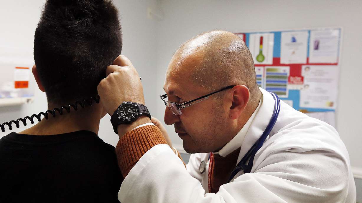 Jose Esparza, a family nurse practitioner at Central City Community Health Center in Salt Lake City, performs an annual checkup on a teenager without insurance on Wednesday, Nov. 4, 2015. (Photo: Ravell Call, Deseret News)