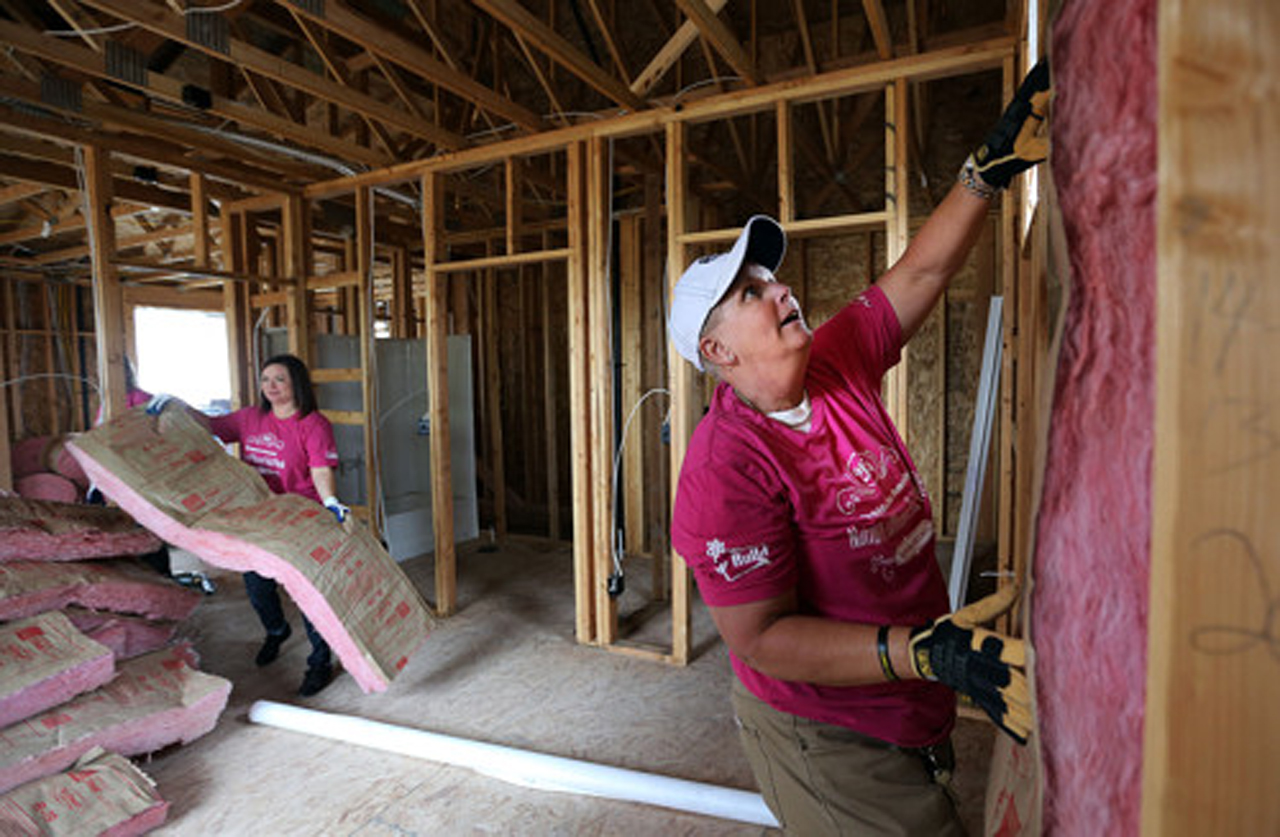 Volunteer Angie Goldberg, left, moves insulation and Lissa Gallego, a store manager at Lowes, places insulation while helping Salt Lake Valley Habitat for Humanity build affordable housing in Kearns, Tuesday, May 5, 2015. Photo: Ravell Call/Deseret News
