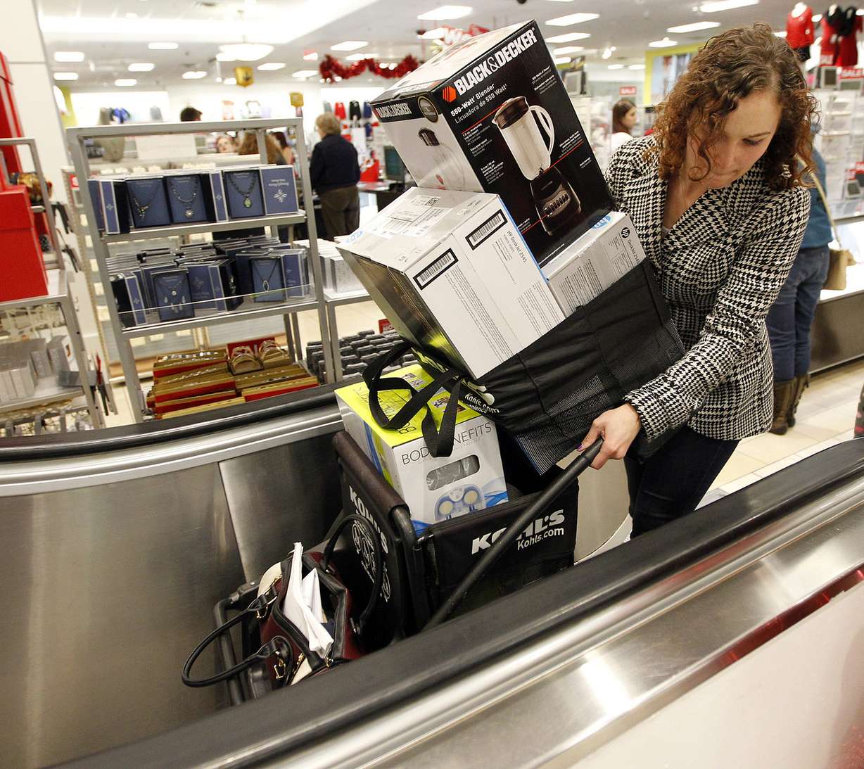 A woman tries to maneuver her purchases up an escalator during Thanksgiving Day shopping at a Kohl's in Salt Lake City, Thursday, Nov. 26, 2015. (Photo: Chris Samuels, Deseret News)