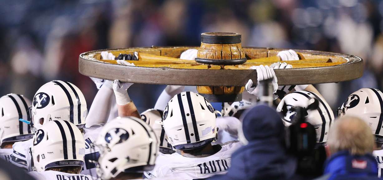Brigham Young players carry the Old Wagon Wheel after beating USU in Logan Saturday, Nov. 28, 2015. BYU won 51-28.