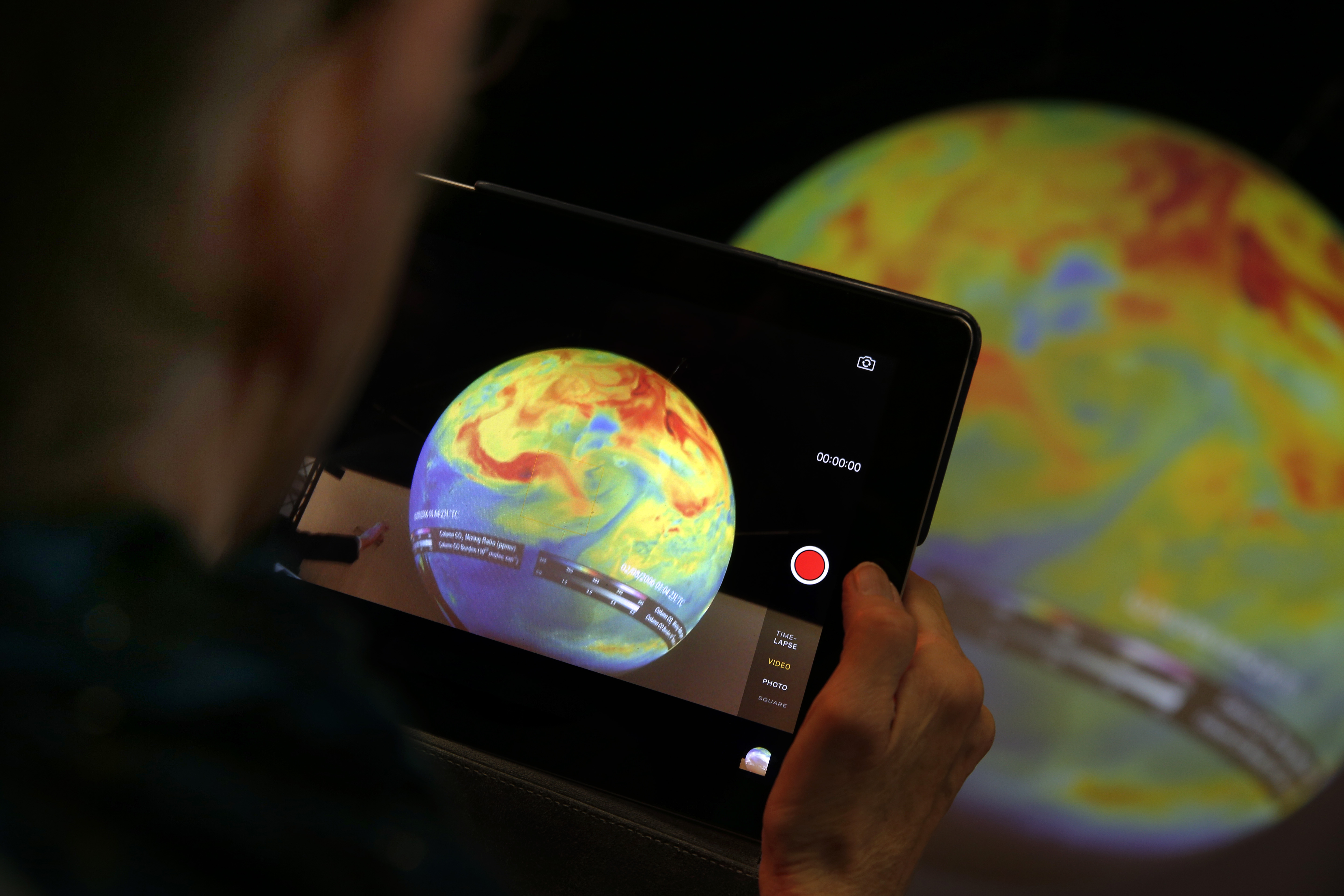 A woman takes a picture of a globe at the COP21, the United Nations Climate Change Conference Monday, Dec. 7, 2015 in Le Bourget, north of Paris. Photo: AP Photo