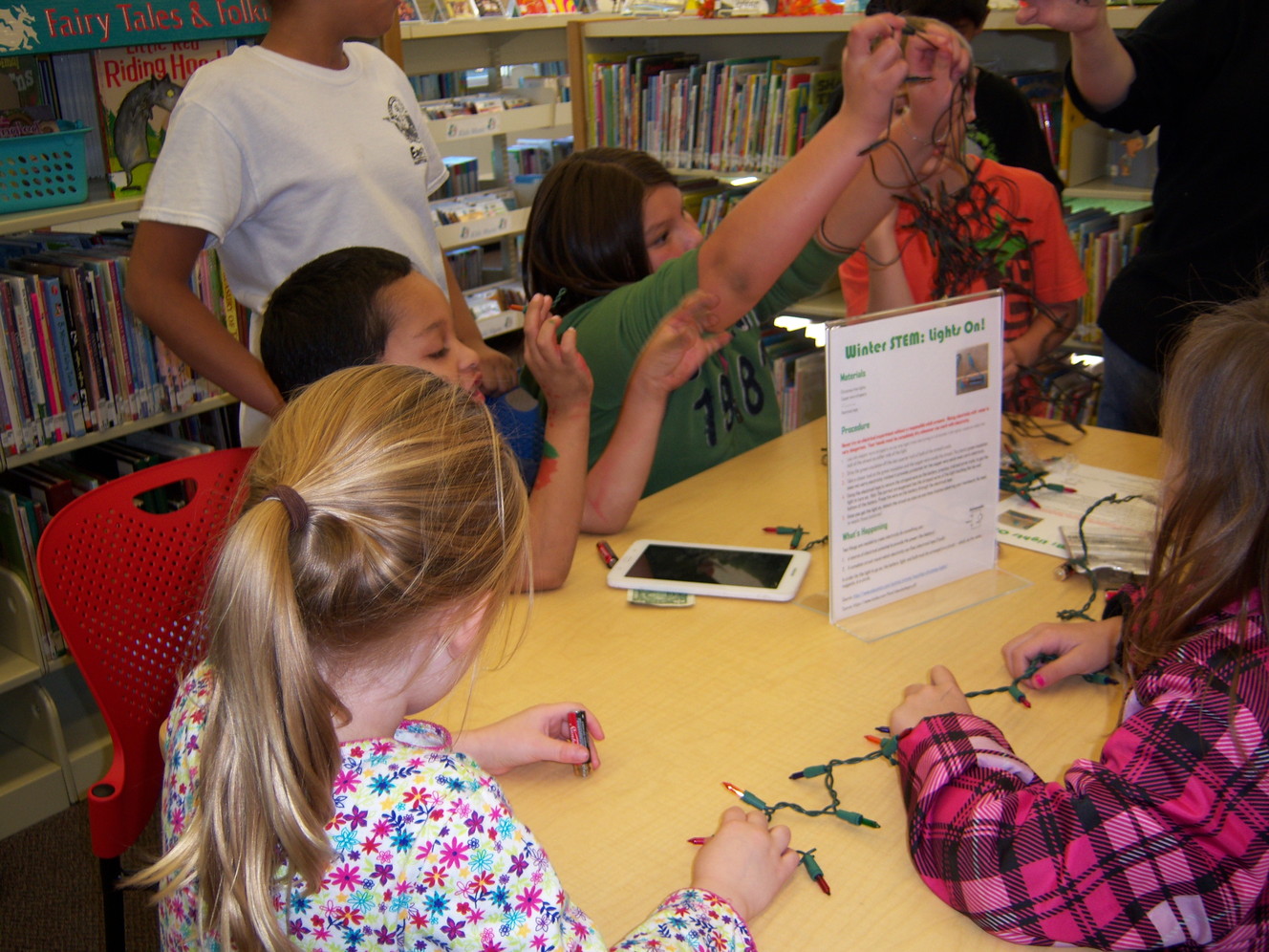 Young library patrons work on their Christmas light circuitry project. (Photo: Jennifer McKague)